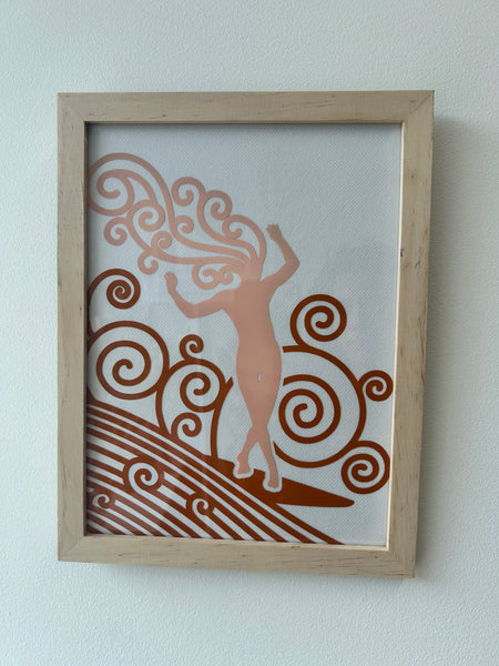 Cadre Surfeuse en bois brut, décor rose poudré et ocre sur vitre avec fond en voile blanc.